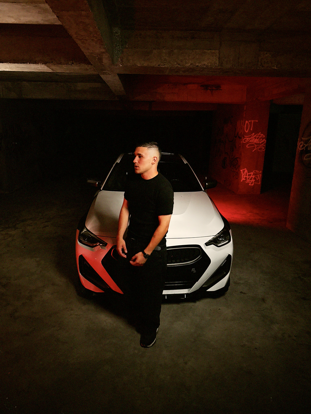 Artista posando recostado sobre un carro