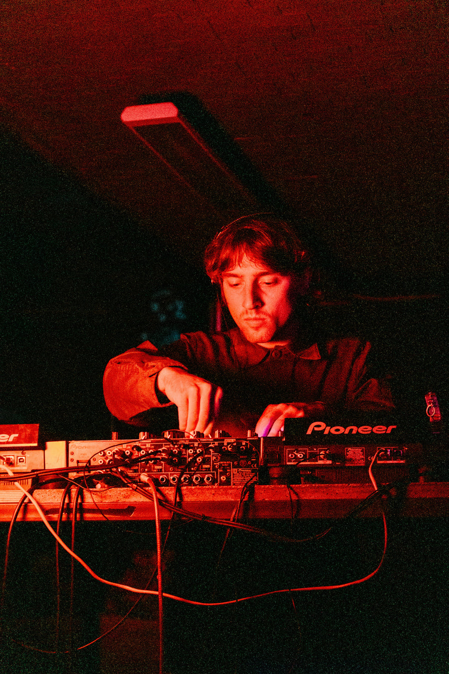 Artista mezclando en una controladora bajo las luces del escenario